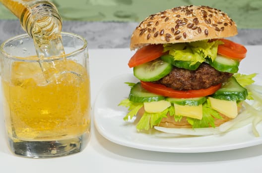 Great Burger and beer is poured into a glass close-up.