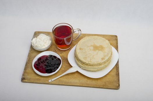 pancakes with jam and milk smeranoy on a wooden plank