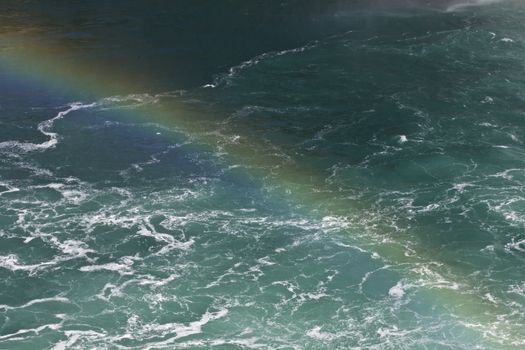 Beautiful photo of the water near amazing Niagara falls with a rainbow