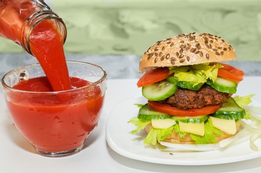 Great Burger and tomato juice poured into glass Cup. Cup