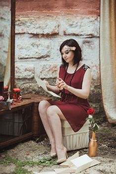 retro girl sitting at a dressing table and reading a letter