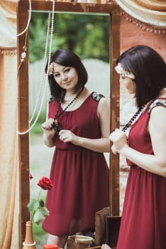 woman in retro style standing and looking in a mirror