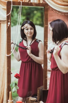 woman in retro style standing and looking in a mirror