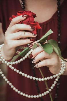 Women's hands in retro style with necklaces and rose