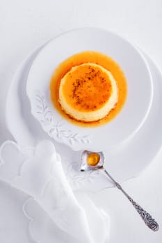 Creme Caramel on a plate served on a table.