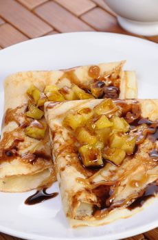 Pancakes sliced apples with caramel and chocolate for breakfast