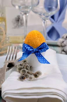 Decorations for Easter.   Golden egg  cups tied with a ribbon on a napkin.  