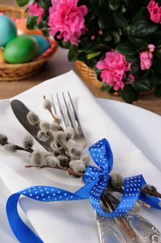 Decorations for Easter. Knife and fork with pussy-willow branches tied with ribbon on a napkin