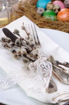 Decorations for Easter. Knife and fork with pussy-willow branches tied with lace on a napkin