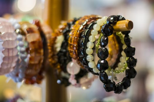 The bracelets hanging on a wooden stand.