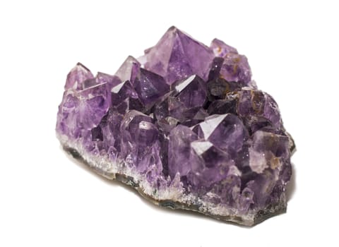 An amethyst stone placed and isolated on white background. Horizontal studio shot.