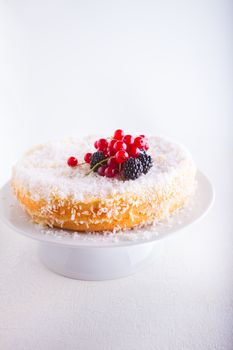 A piece of Homemade coconut cake on a white plate.