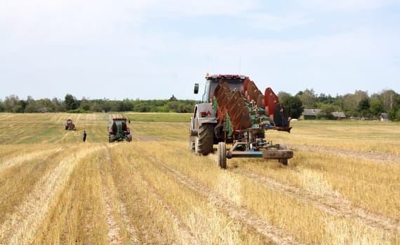 after harvesting, the tractor with working plows went to raise the plow