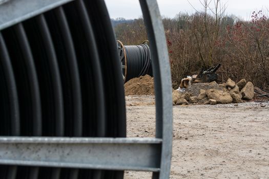 Steel roller with fiber optic cables for the installation of data cables on a construction site.