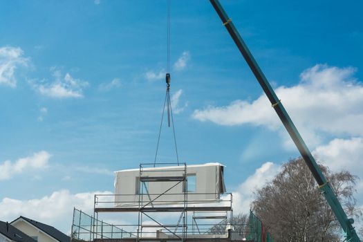 Mobile Crane car on a construction site. Lifts up a concrete wall.