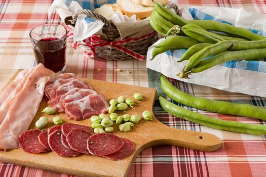 Trattoria table with cold meats broad bean and red wine