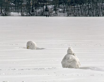 Partially built snowmen on Lake Harriet in Minneapolis, Minnesota.