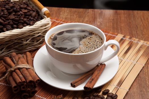 cup of coffee, spice and roasted beans in the basket