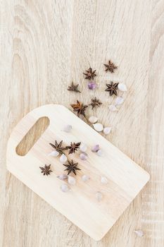 Star anise spice fruits and seed and garlic on wood chopping board and wood table from above