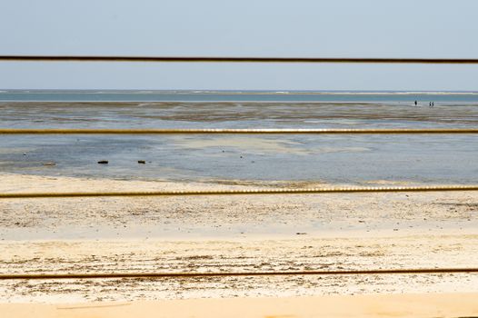 Yellow steel cable with the ocean in background on the beach of Bamburi in Kenya