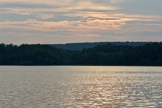 Beautiful landscape with the lake and the forest on the sunset