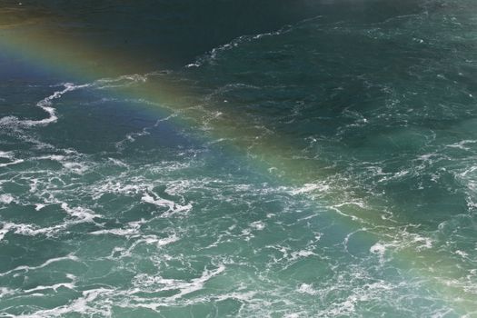 Beautiful photo of the water near amazing Niagara falls with a rainbow