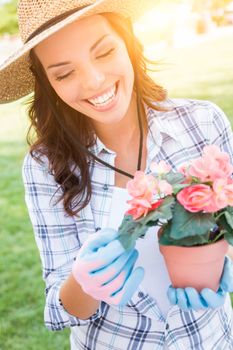 Happy Young Adult Woman Wearing Hat and Gloves Gardening Outdoors.