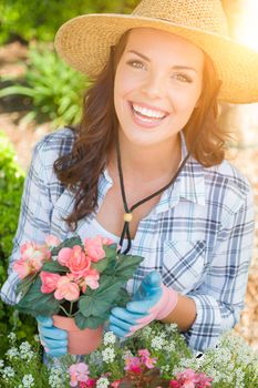 Happy Young Adult Woman Wearing Hat and Gloves Gardening Outdoors.