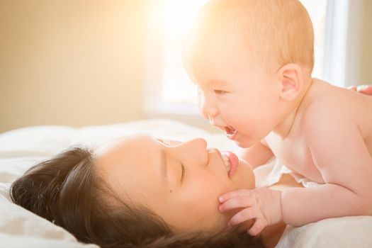 Young Mixed Race Chinese and Caucasian Baby Boy Laying In His Bed with His Mother.