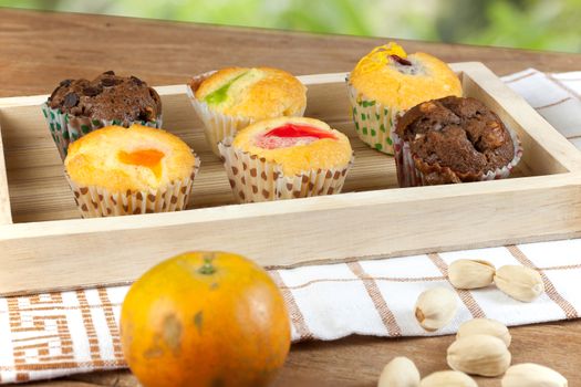 Cup cake various flavors in wood tray on wood table