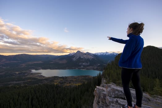 Girl points out view of a lake from the top of a hike