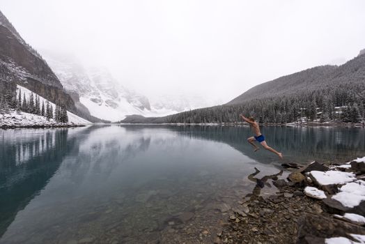 Man jumps into freezing cold Moraine lake after a snowfall