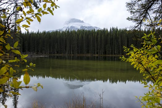 Mountain reflection in a calm green lake during fall hike