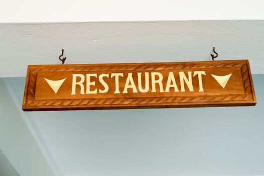 Directional board of the dining room chiselled in brown wood and white lettering