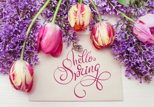 frame from tulips and lilac and place for text greeting card and text Hello Spring. Calligraphy lettering.