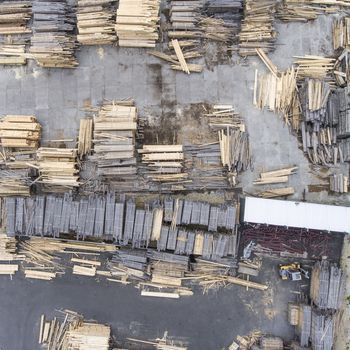 Sawmill. Felled trees, logs stacked in a pile. View from above. Industrial background.