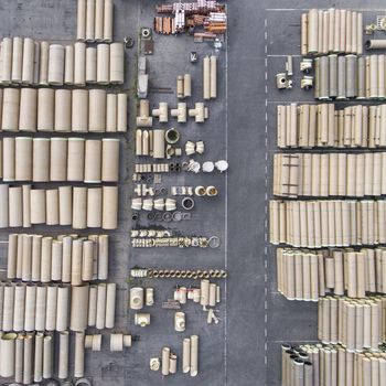 Industrial concrete drainage pipes stacked for construction. New tubes. Storage place. View from above.