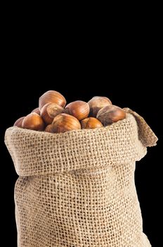 some hazelnuts placed over a black  background