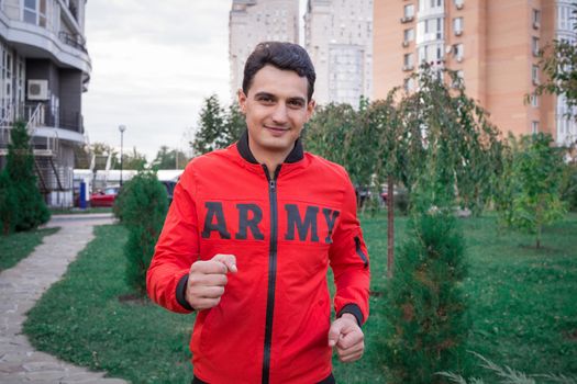 Young fitness man runs during his training workout in park outdoor