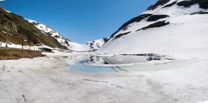 Oberalp pass, Switzerland : Artificial lake ice. The lake is illuminated by the sun during a beautiful day on the day of the Feast of the Ascension