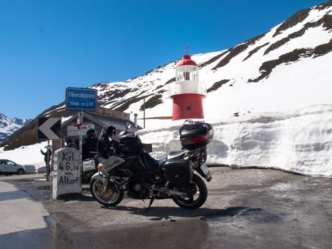 editorial, Andermatt, Switzerland - May 14, 2015: Lighthouse Oberalppass. The lighthouse is surrounded by snow and is illuminated by the sun during a beautiful day on the day of the Feast of the Ascension