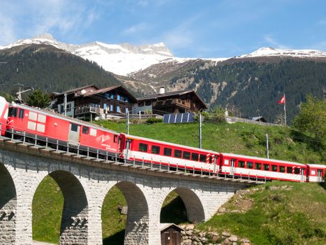 Surselva, Switzerland - May 14, 2015: Bridge of the Rhaetian Railway in the Surselva valley. The deck is illuminated by the sun during a beautiful day on the day of the Feast of the Ascension.