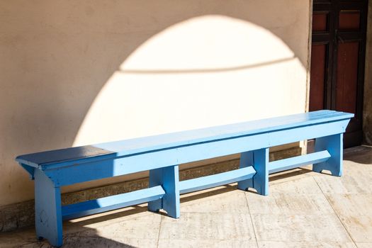 blue wooden bench in the courtyard of a convent