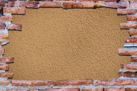 Ancient red brick wall with a hole over a bakground yellow.