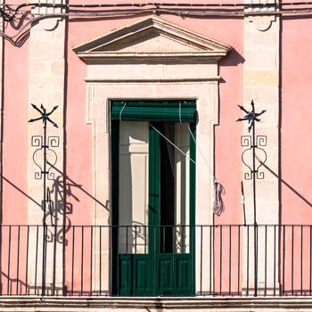 green door of an old Sicilian pink house