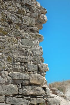 collapsed stone wall in ruins on sky background