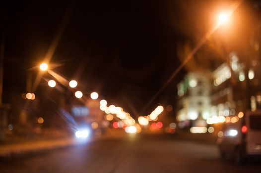 Night city street lighting lanterns and cars.