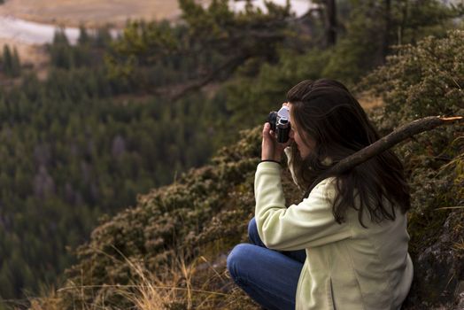 Woman taking picture of landscape of green forest