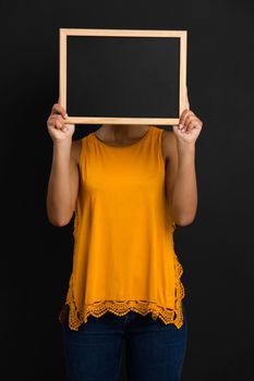 Beautiful African American woman showing something on a chalkboard