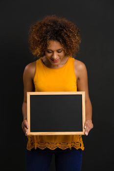 Beautiful African American woman showing something on a chalkboard